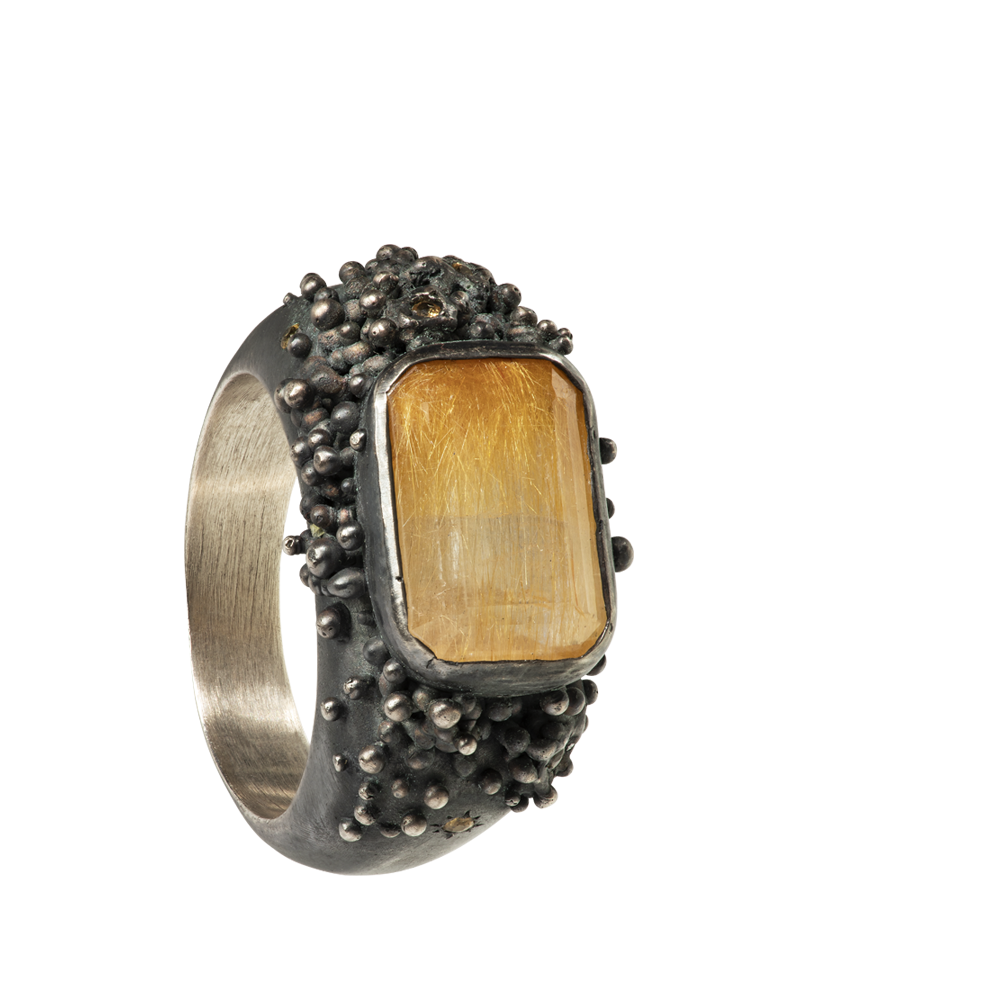 A massif sterling silver ring with a beautiful emerald-cut rutilated quartz and six yellow sapphires. The ring is hand sculpted and cast in sterling silver with a deep black patina.