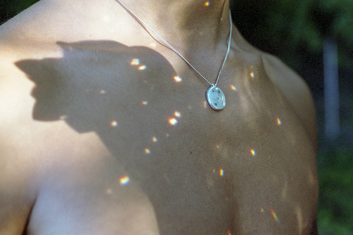 A precious but rough sterling silver medallion set with four tsavorite garnets and celestial engravings. Hand sculpted by Violette Stehli. Photo by Angélique Stehli.