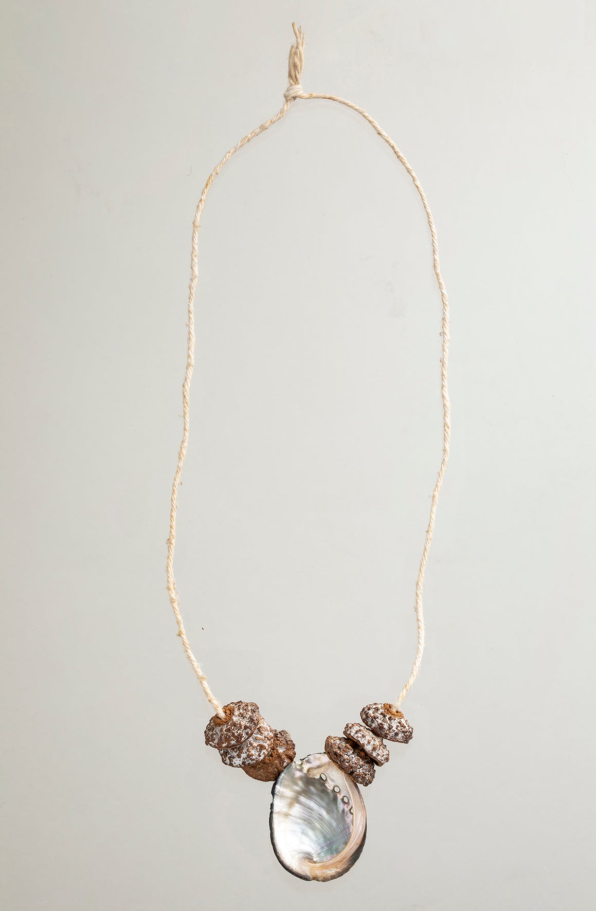 A sterling silver and gold vermeil necklace made from casts of eucalyptus seed caps and an abalone shell. Made by Violette Stehli