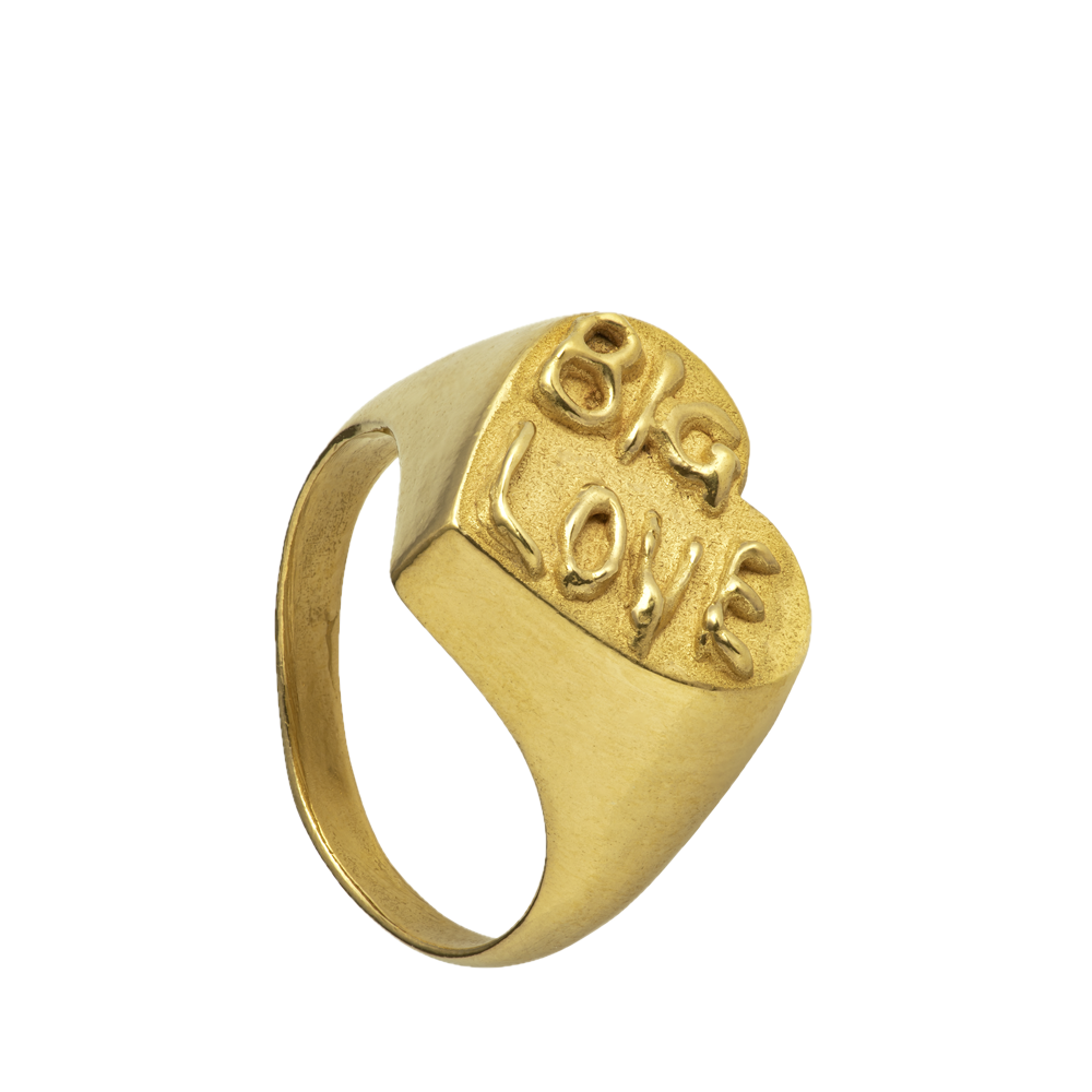A large 18-karat gold heart-shaped signet ring with Big Love written on its surface. The font is evocative of psychedelic posters. Handmade by Violette Stehli.