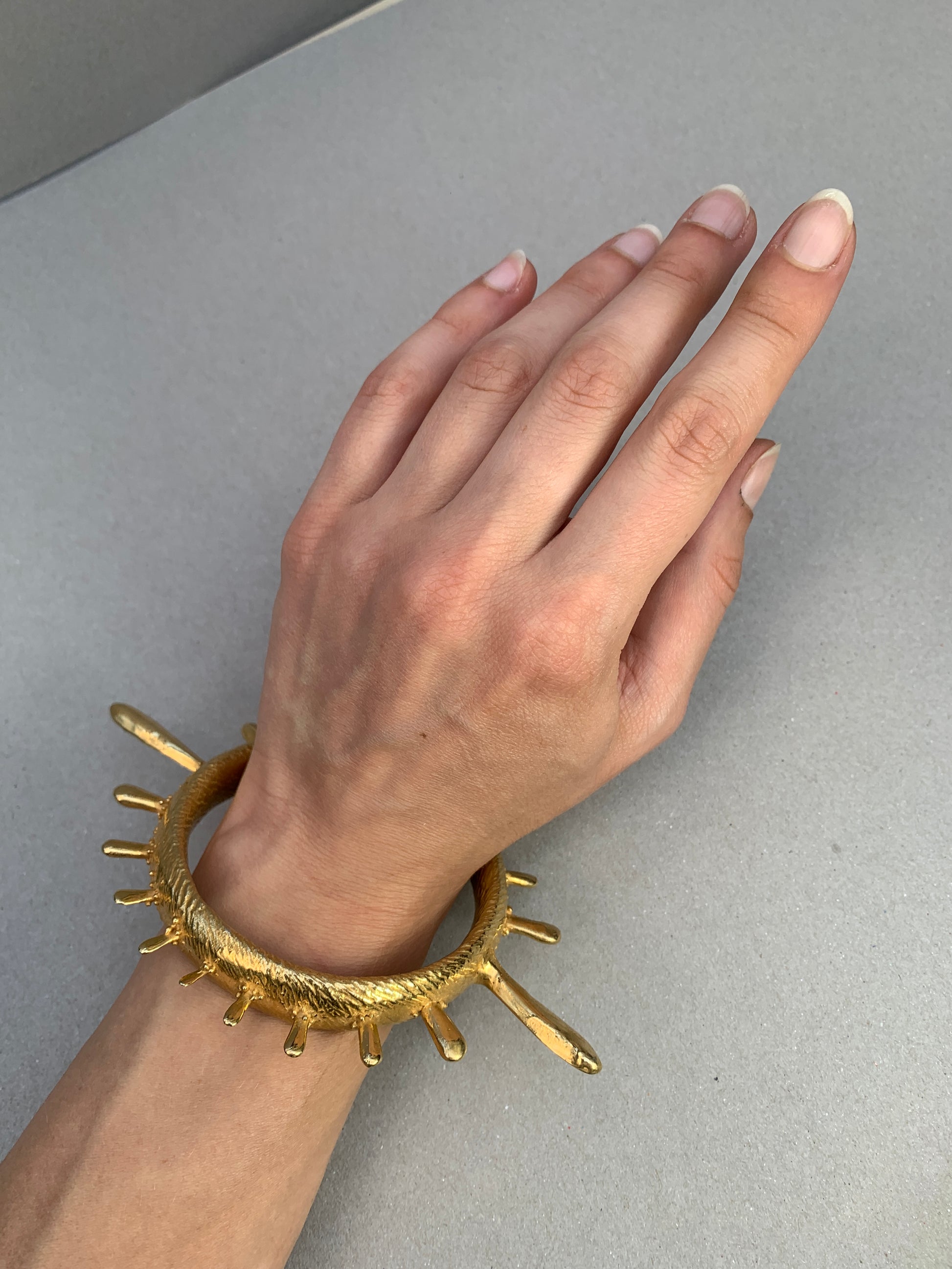 A colossal gold vermeil bangle adorned with sea urchin spines and delicate granulation details evoking ancient Etruscan jewelry.