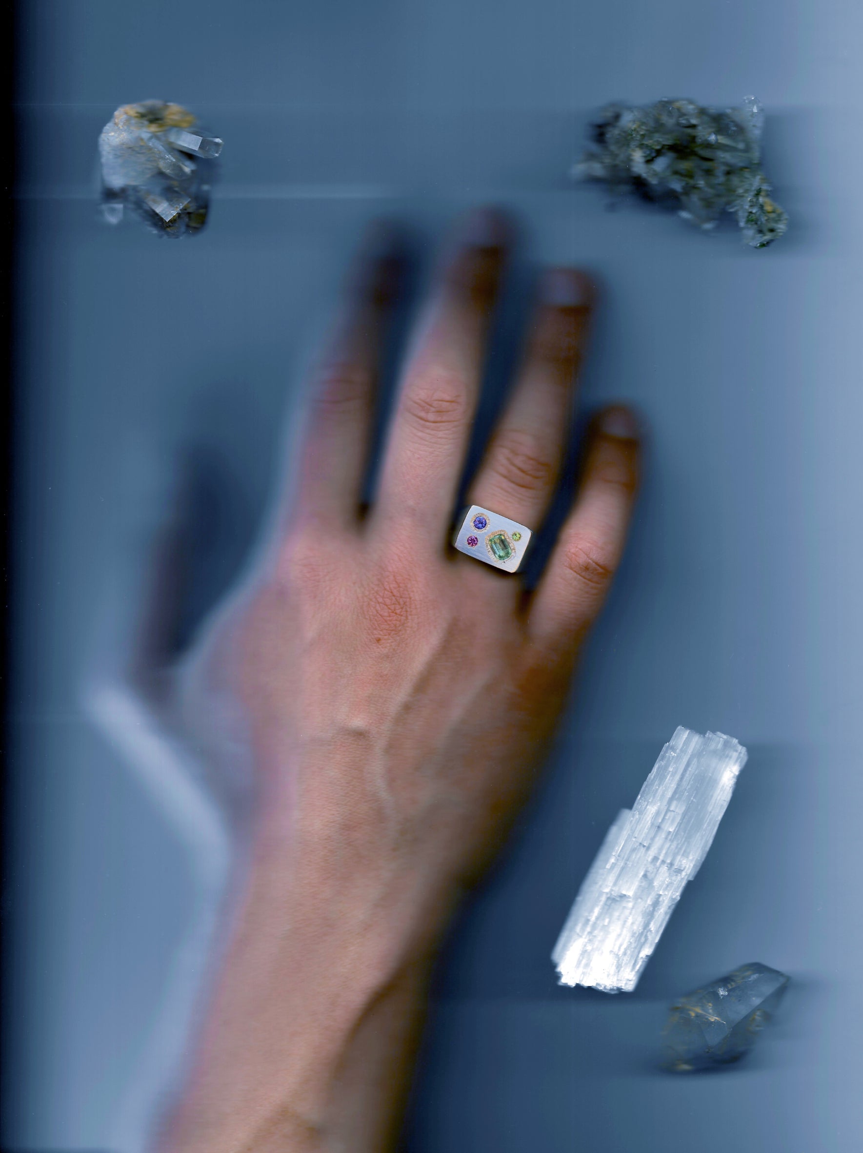 A rough but precious rectangular signet in sterling silver set with a mint-green tourmaline, a peridot, a tanzanite and a rhodolite garnet. Hand sculpted by Violette Stehli.