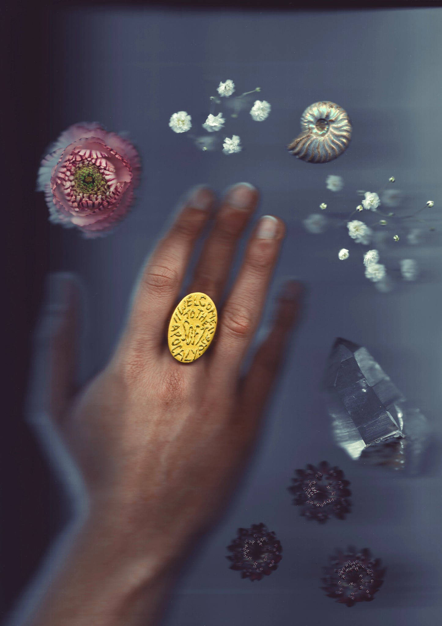 A massive gold vermeil ring made by Violette Stehli. Set with sapphires and peridot and embossed with handwritten text that reads "welcome to the soft apocalypse".
