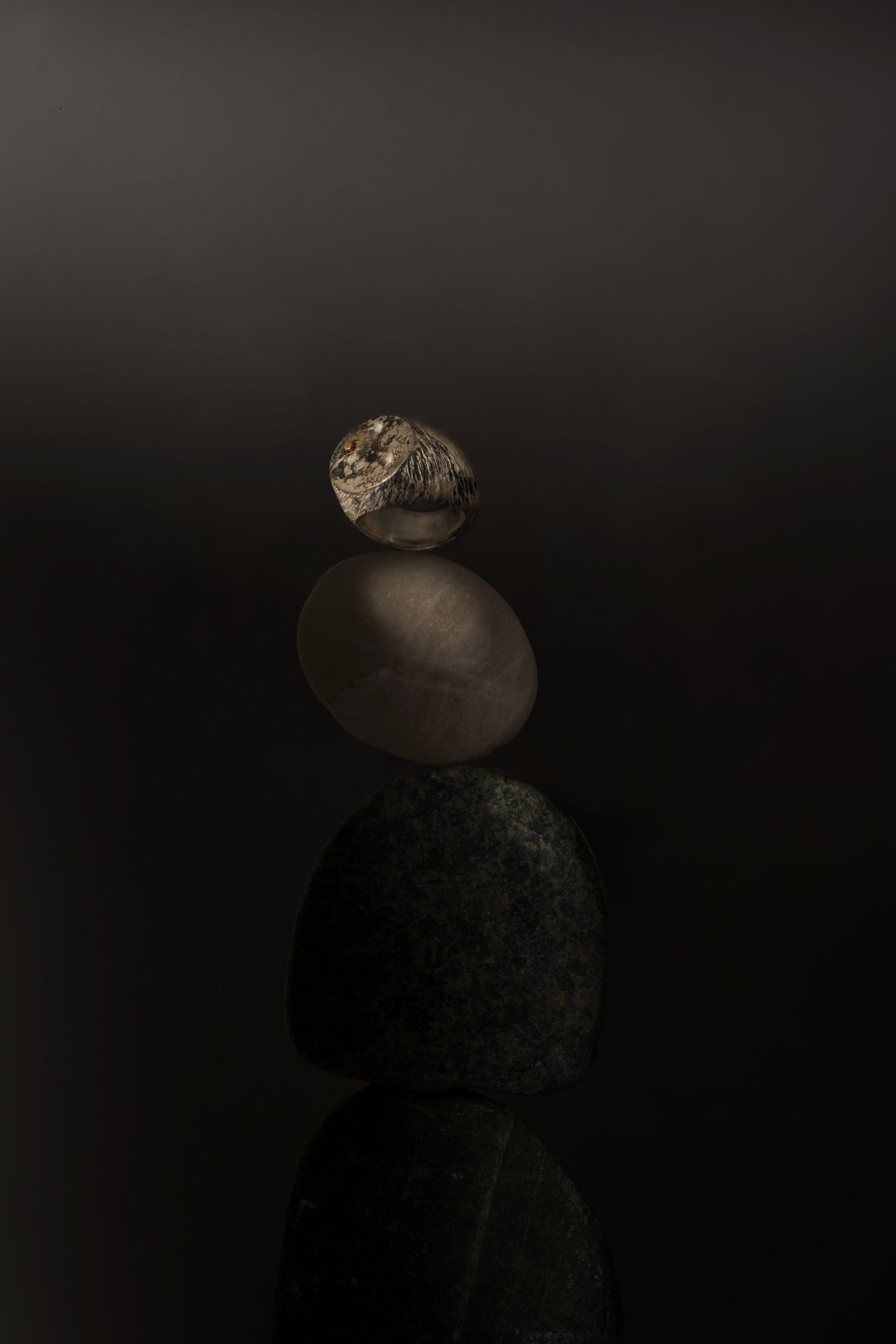 A massive distressed sterling silver and 18-karat gold signet set with opals and sapphires. The ring looks like the surface of the moon annd is hand-sculpted by Violette Stehli. Photo by Benjamin Neustadt.