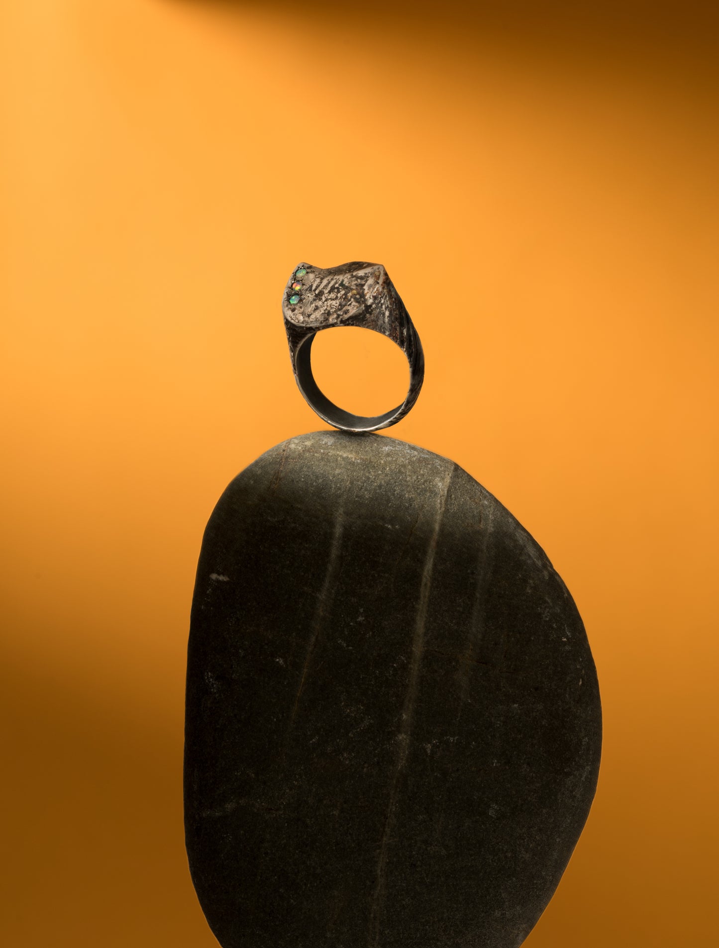 A textured distressed silver signet ring set with three opals. Made by Violette Stehli, photograph by Benjamin Neustadt.