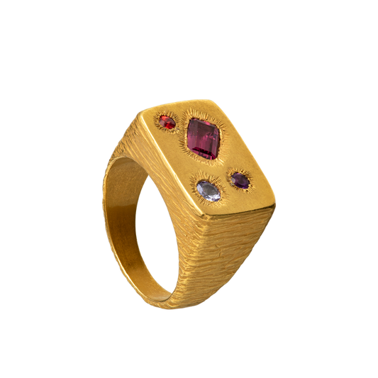 A rough but precious rectangular signet in 18-karat gold set with four precious stones. Hand sculpted by Violette Stehli.