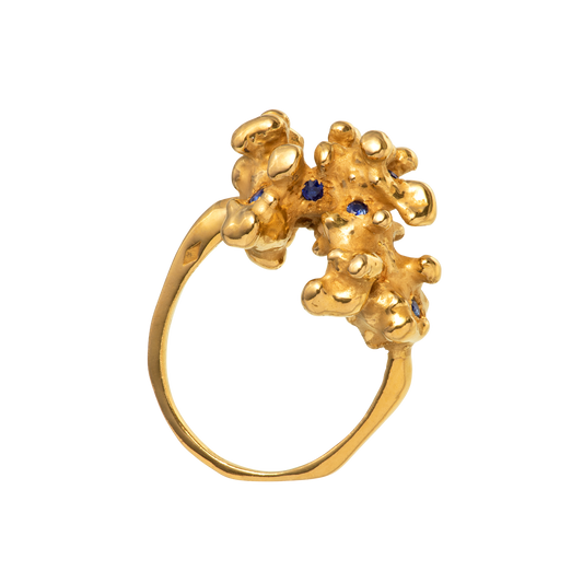 A gold ring made from a cast of a fragment of coral as set with 10 blue sapphires. Handmade by Violette Stehli.
