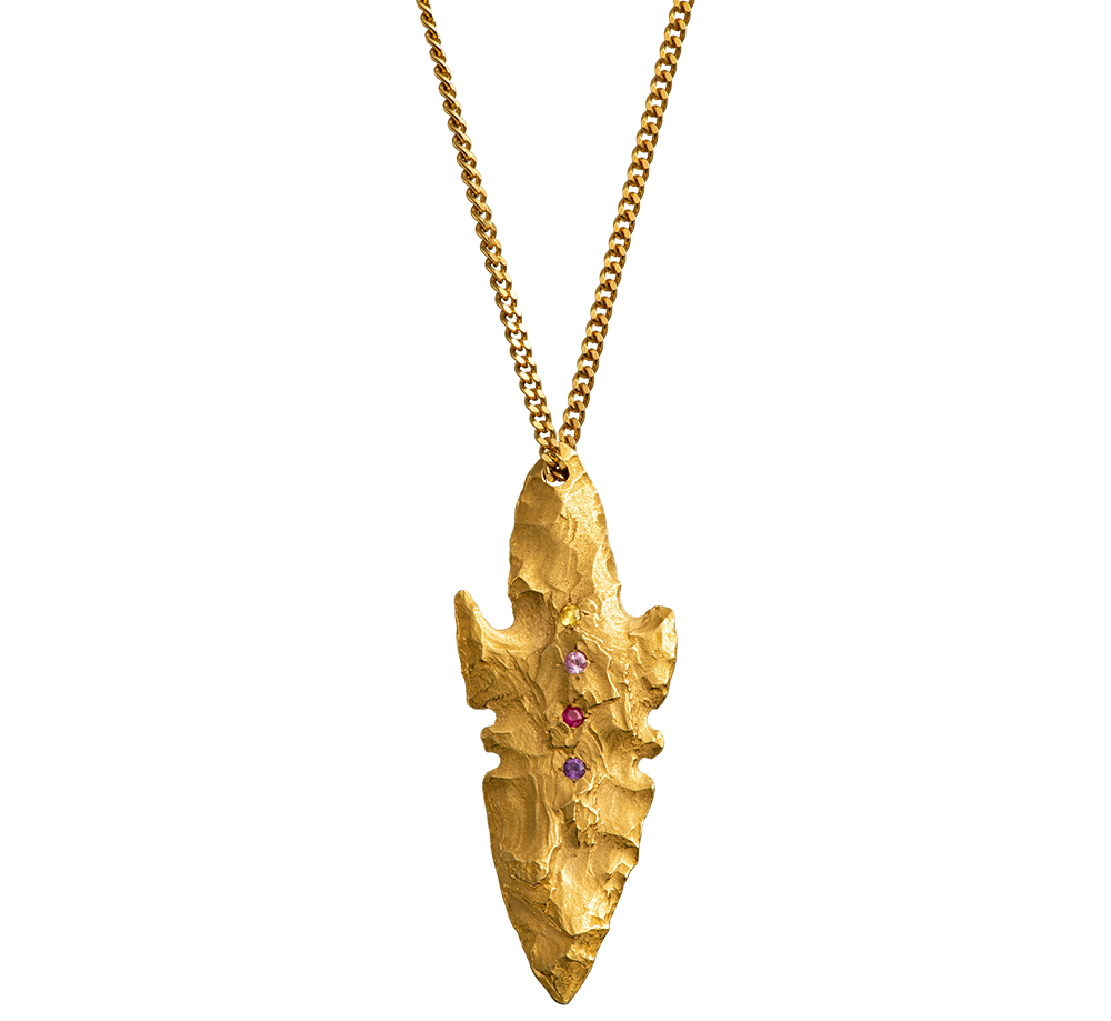 A pendant made from the cast of a neolithic era arrowhead. It is set with ruby, amethyst, pink and yellow sapphires on a curb-link chain. Handmade by Violette Stehli