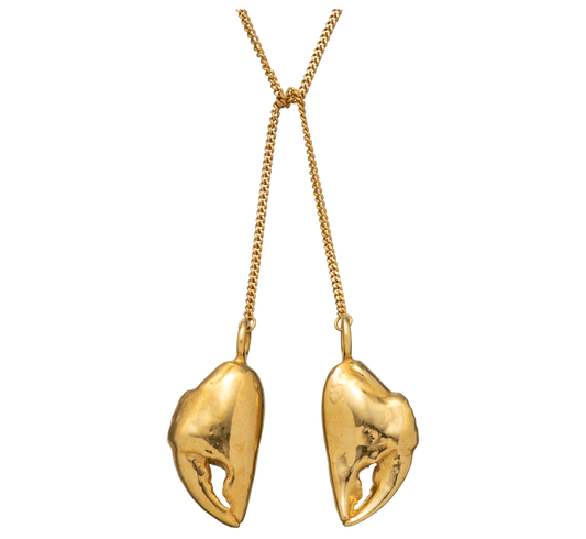 A close up shot of a gold vermeil lariat necklace made from casts of crab claws by Violette Stehli