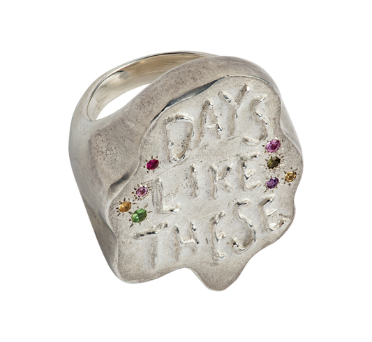 A giant, sculptural sterling silver ring by Violette Stehli. Set with peridot, sapphire, amethyst and ruby. The ring features a hand written embossed text that reads "Days Like These"