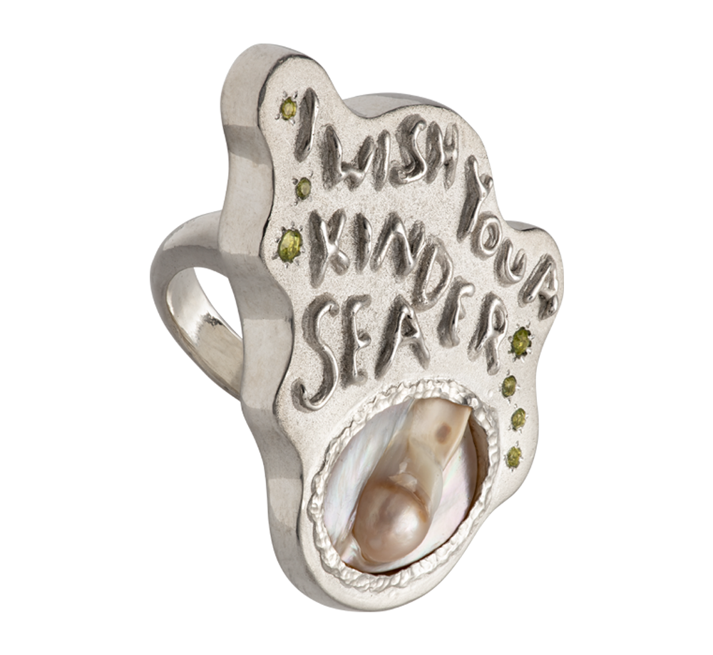 A large silver ring made from responsible jewellery council certified sterling silver, a pearl and set with peridot stones. The ring features a quote by Emily Dickinson that ready: I Wish You A Kinder Sea. The ring is hand-sculpted by Violette Stehli.