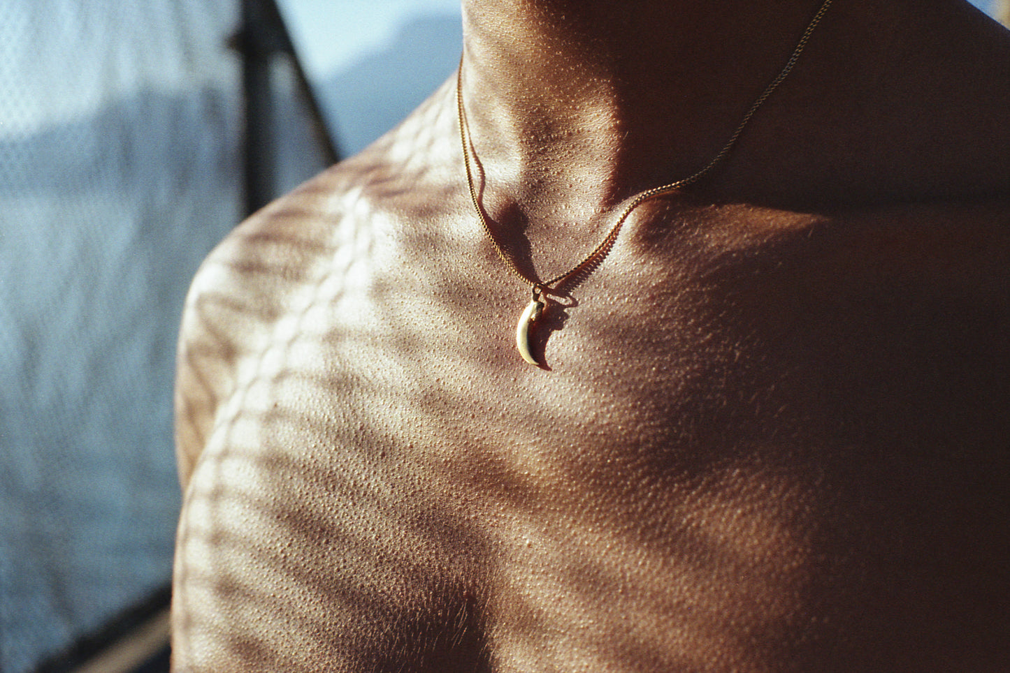 A photo of Ulysse wearing the Violette Stehli bat claw pendant.