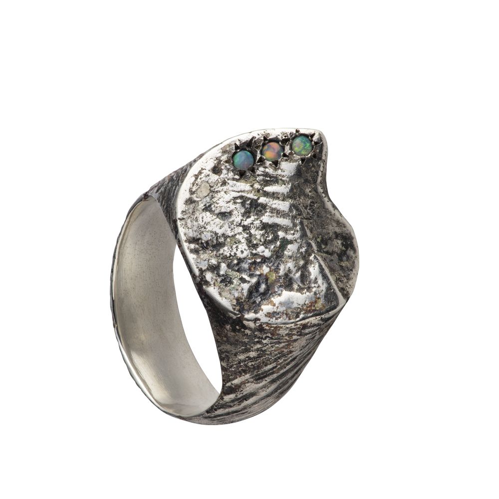 A textured distressed silver signet ring set with three opals. Made by Violette Stehli.