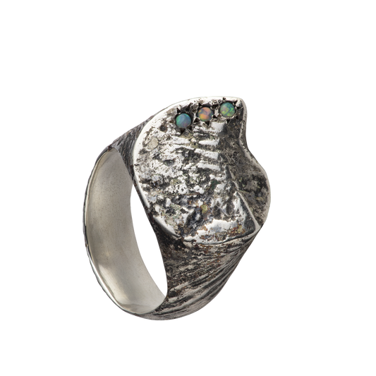 A textured distressed silver signet ring set with three opals. Made by Violette Stehli.