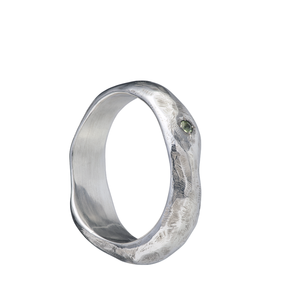 A fluid and textured sterling silver band set with a green sapphire. Made by Violette Stehli.