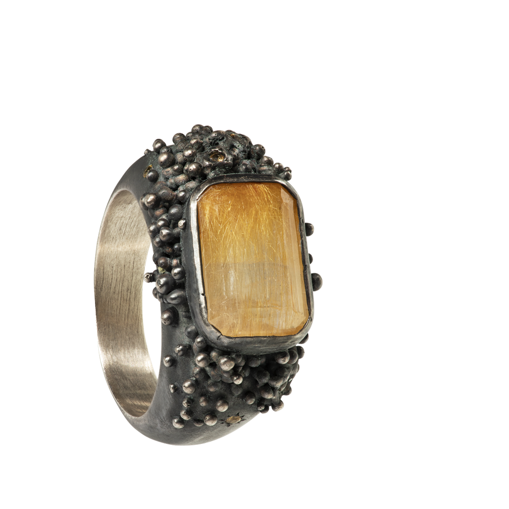  A massif sterling silver ring with a beautiful emerald-cut rutilated quartz and six yellow sapphires. The ring is hand sculpted and cast in sterling silver with a deep black patina. 