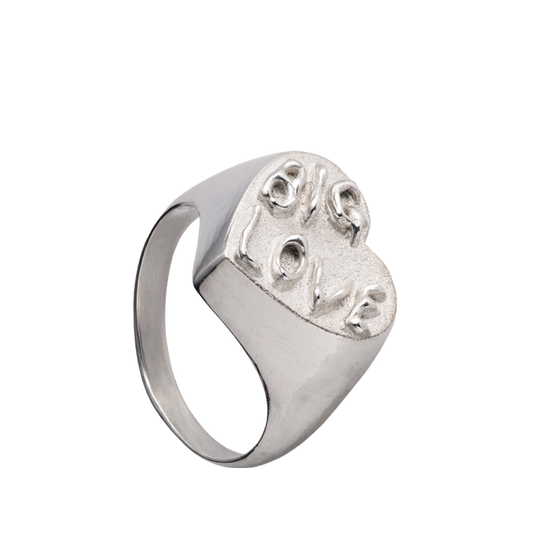 A hand sculpted heart-shaped signet ring made from responsible jewelry council certified sterling silver. The surface of the ring has the words "Big Love" embossed on it in a had-written psychedelic font.