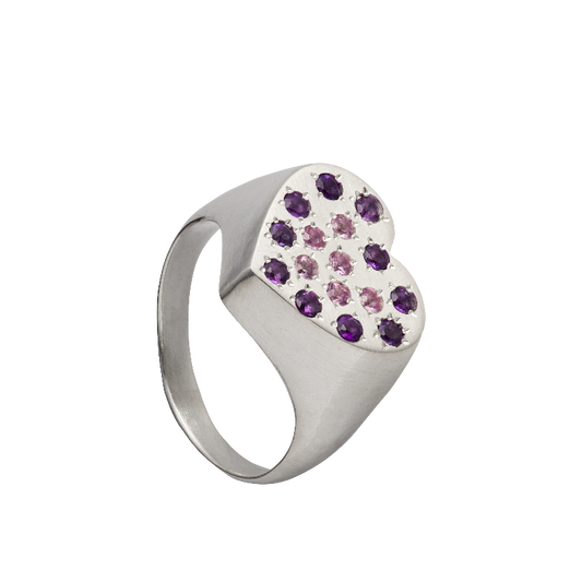 A hand sculpted heart-shaped signet ring made from responsible jewelry council certified sterling silver. The surface of the ring is set with amethysts and pink sapphires. Handmade by Violette Stehli.