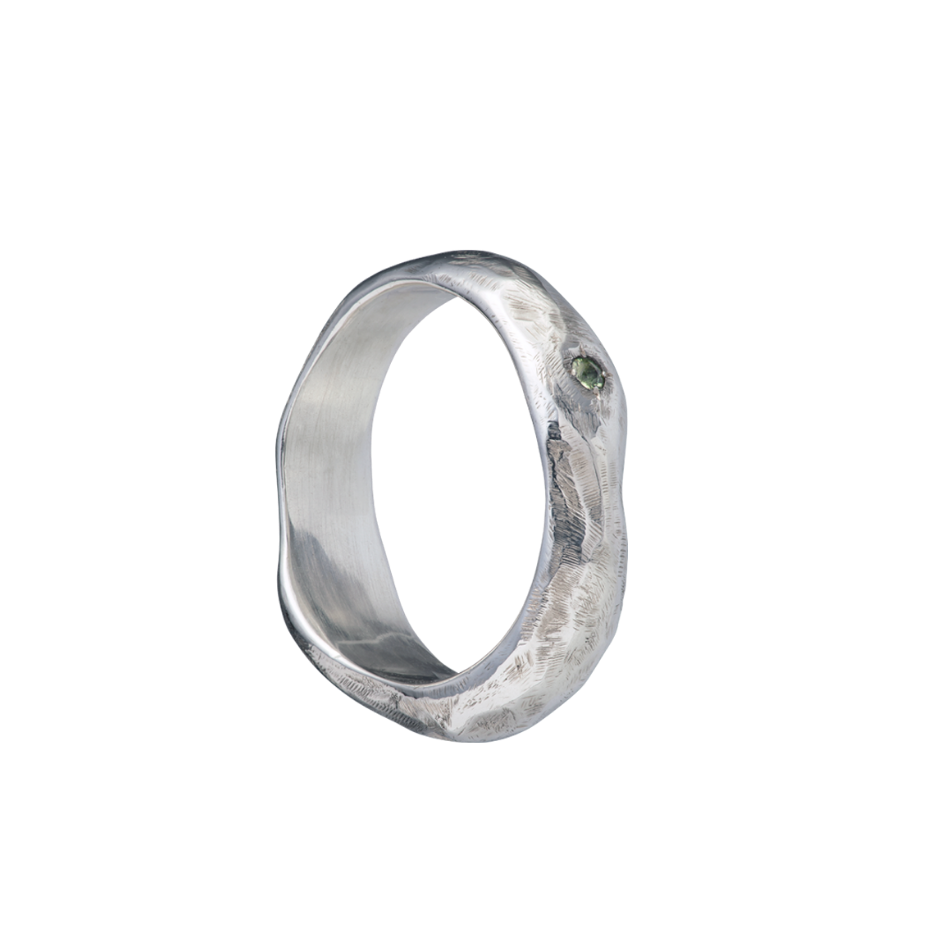 A fluid and textured sterling silver band set with a green sapphire. Made by Violette Stehli.