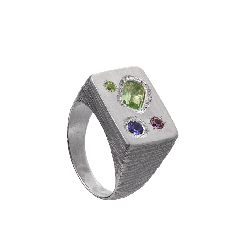A rough but precious rectangular signet in sterling silver set with a mint-green tourmaline, a peridot, a tanzanite and a rhodolite garnet. Hand sculpted by Violette Stehli.