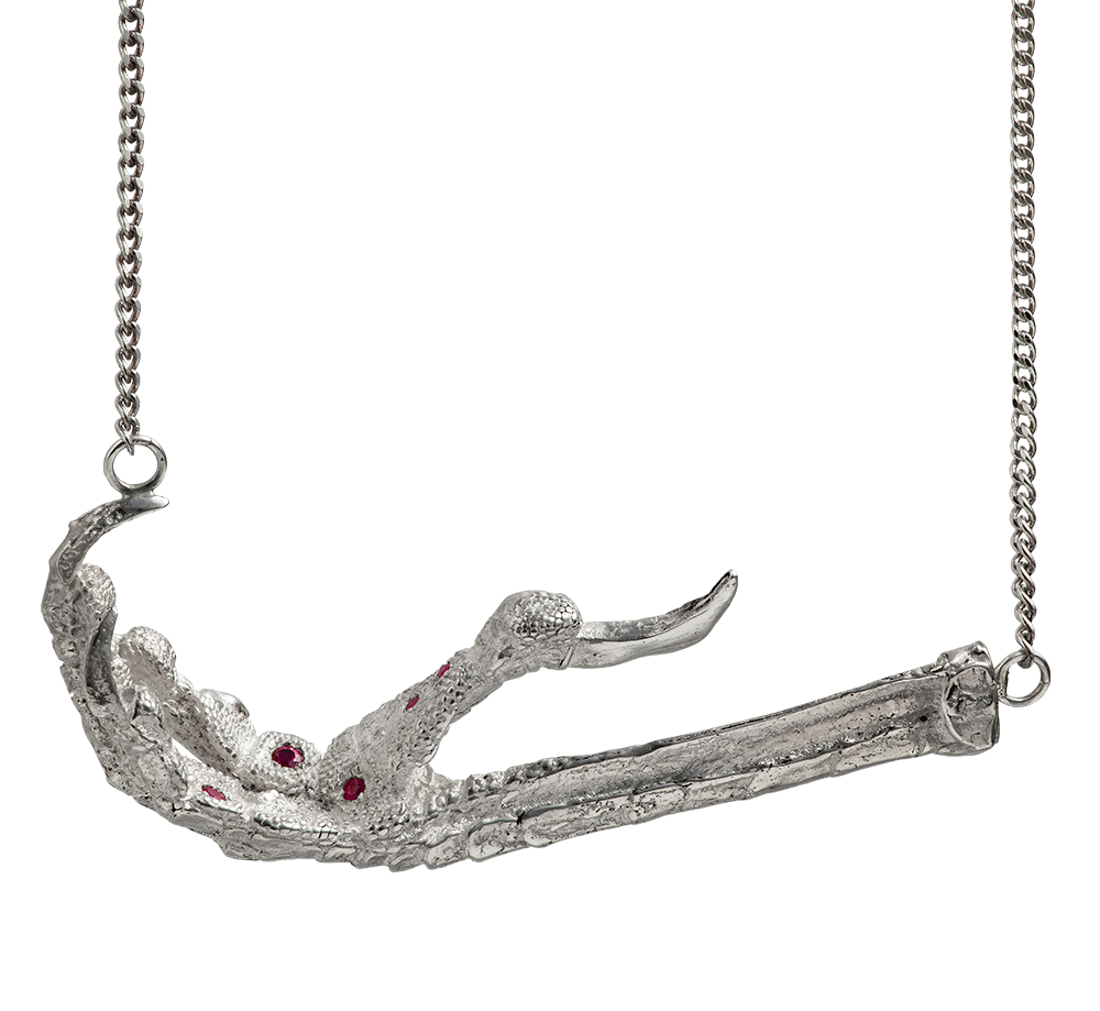 A necklace cast from a crows foot and set with rubies by Violette Stehli. The necklace is a choker on a curb-link chain.