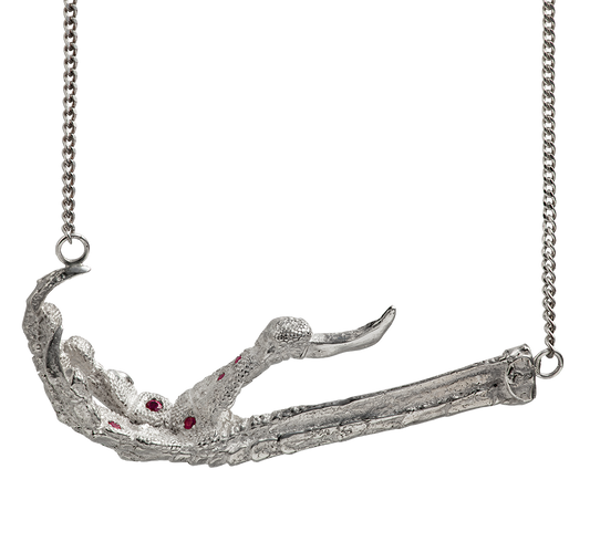 A necklace cast from a crows foot and set with rubies by Violette Stehli. The necklace is a choker on a curb-link chain.