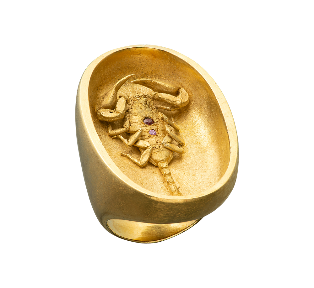 A large gold ring made by Violette Stehli featuring a scorpion set with sapphire and garnet. The ring is made using the lost wax casting process.