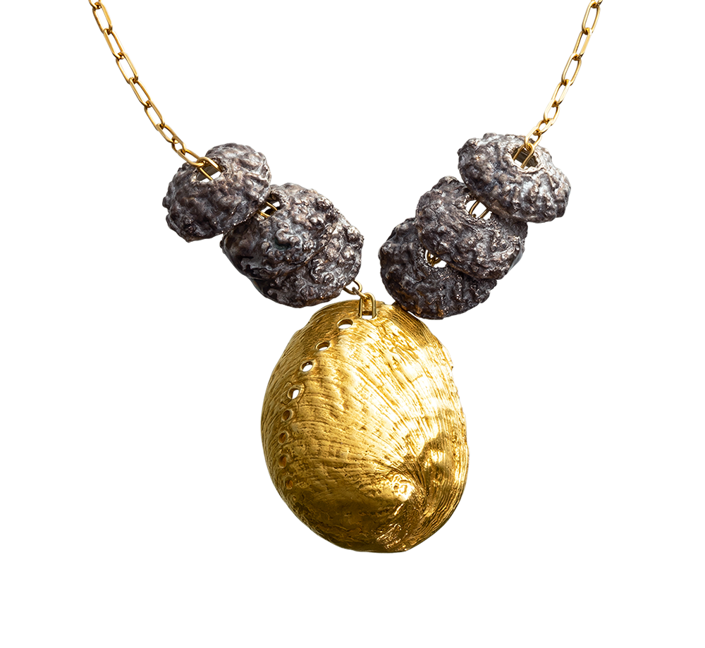 A close-up image of a sterling silver and gold vermeil necklace made from casts of eucalyptus seed caps and an abalone shell. Made by Violette Stehli
