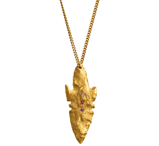 A pendant made from the cast of a neolithic era arrowhead. It is set with ruby, amethyst, pink and yellow sapphires on a curb-link chain. Handmade by Violette Stehli