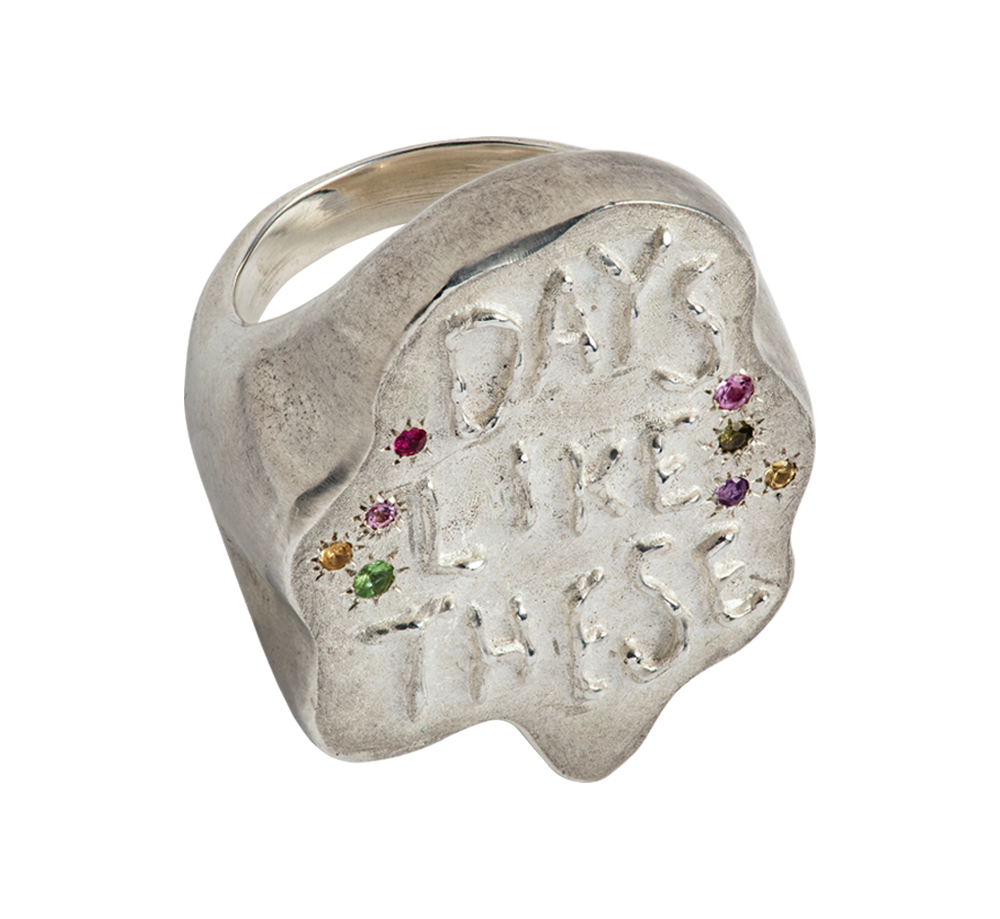 A giant, sculptural sterling silver ring by Violette Stehli. Set with peridot, sapphire, amethyst and ruby. The ring features a hand written embossed text that reads "Days Like These"