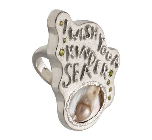 A large silver ring made from responsible jewellery council certified sterling silver, a pearl and set with peridot stones. The ring features a quote by Emily Dickinson that ready: I Wish You A Kinder Sea. The ring is hand-sculpted by Violette Stehli.